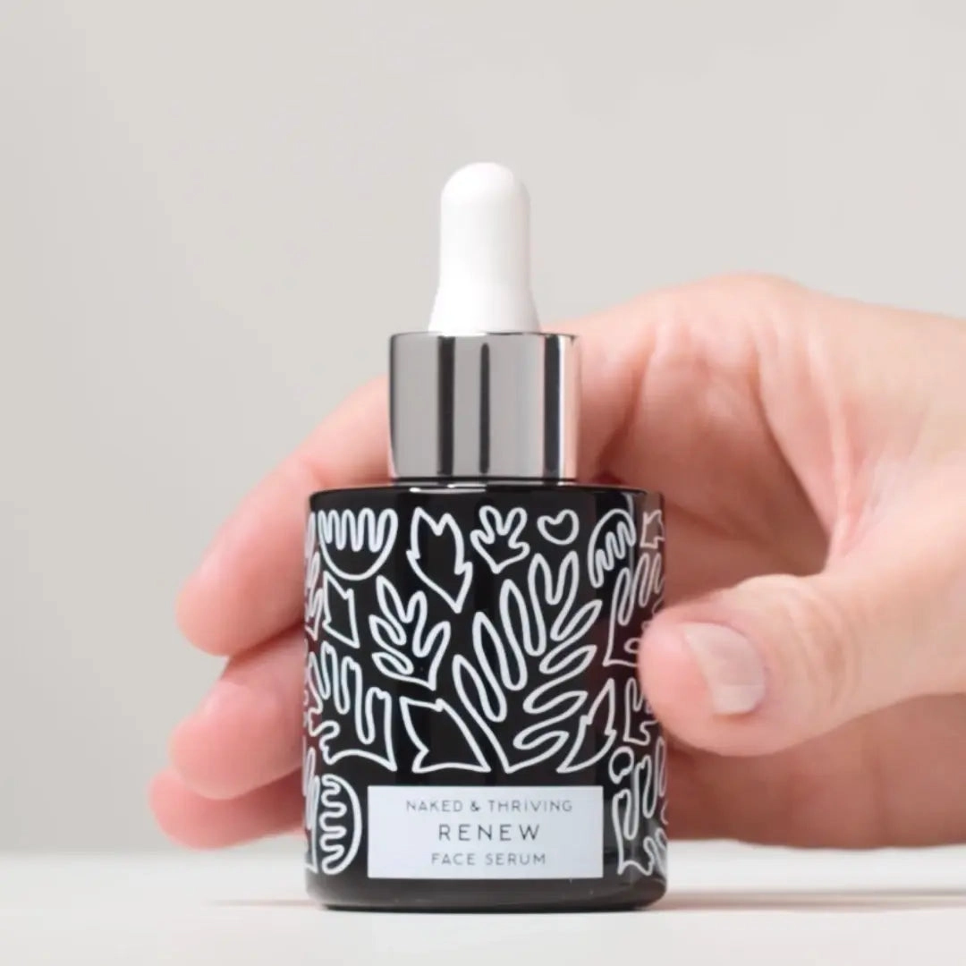 Hand holding a patterned glass dropper bottle